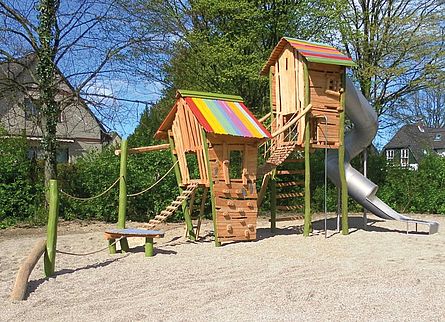 Modell eines bunten Holzspielhauses mit Klettermöglichkeiten für den Streckerplatz