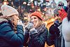 Eine Gruppe von Freunden in Winterkleidung trinkt Glühwein.