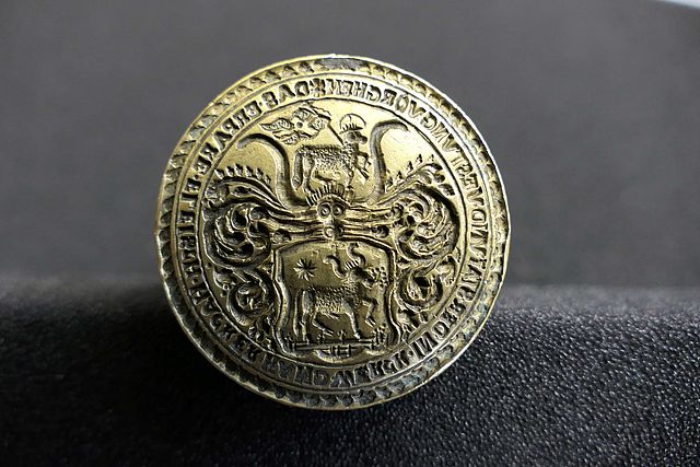 Die Unterseite eine Messingsiegels zeigt unter anderem in der oberen und unteren Hälfte ein Lamm.