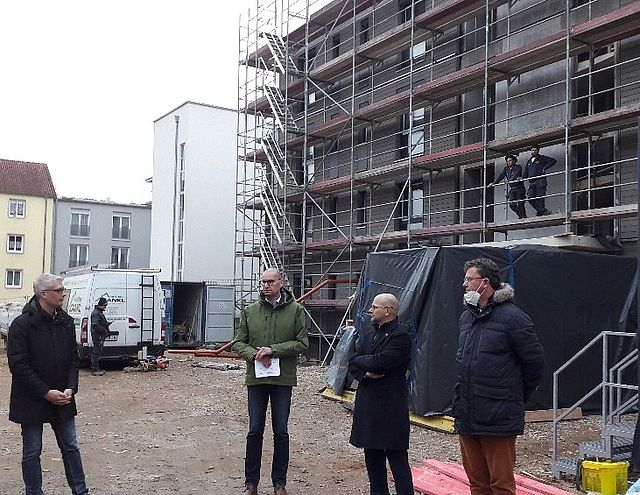 Vier Personen vor Rohbau