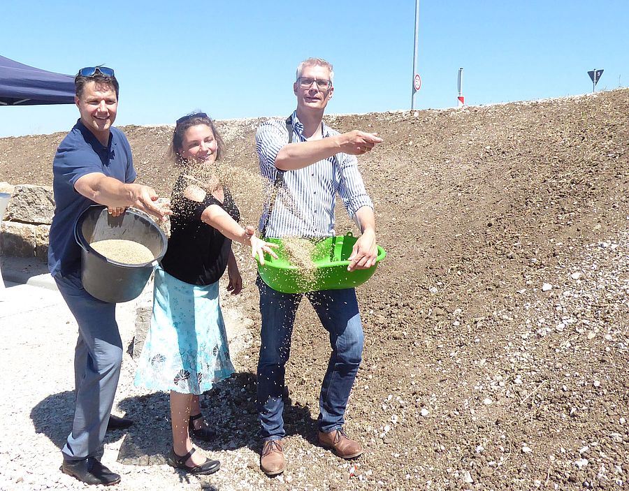 Oberbürgermeister Dr. Uwe Kirschstein (rechts) sät mit Mitarbeiter*innen am Pendlerparkplatz Kersbach symbolisch an.