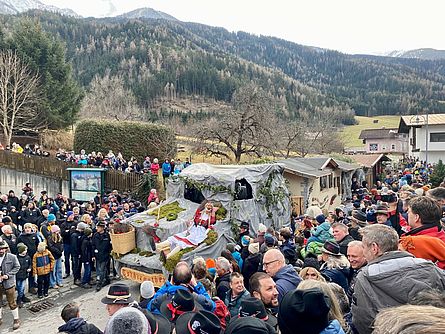 Der Roppener Faschingszug bewegt sich durch den Ort. Viele Besuchende begleiten das Spektakel.