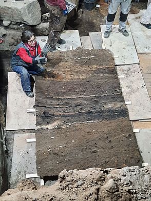 Künstlerin Heike Krainitzki erläutert das fertige Sedimentstransferpräparat, das am Boden abgelegt wurde.