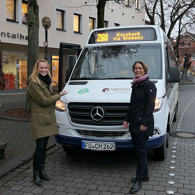 Zwei Personen vor Midibus