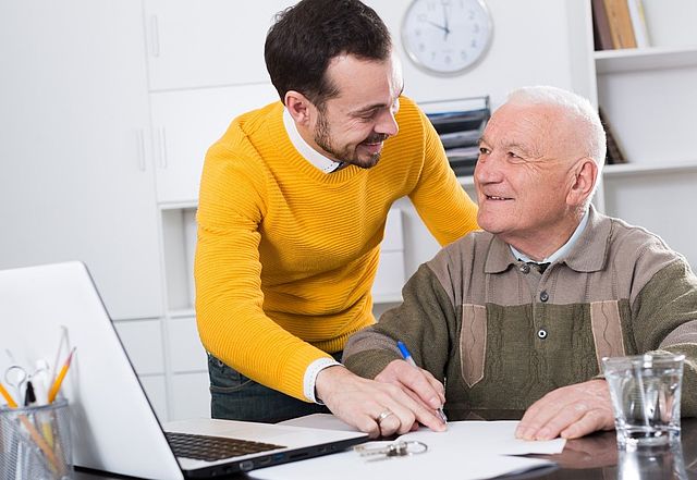 Junger Mann mit älterem Mann im Gespräch.