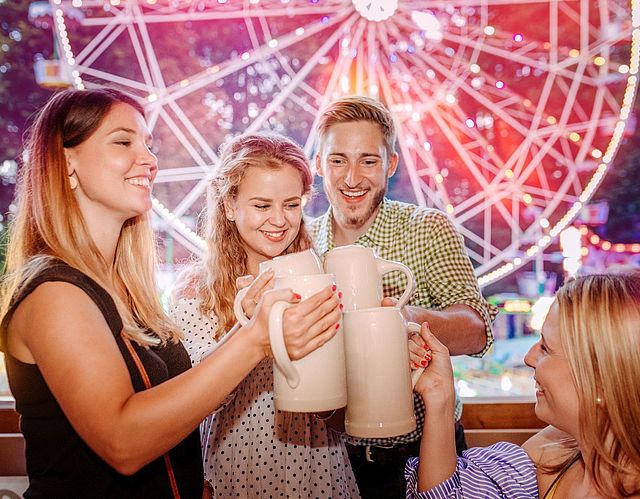 Feiernde Personen mit Bierkrügen