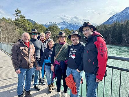 Die Forchheimer Delegation steht auf einer Brücke über einem breiten Fluss vor alpenländischer Kulisse.