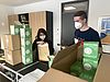 Frau und Mann verpacken Masken in Kartons