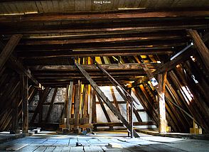 Man sieht einen alten Dachstuhl und Holzbalken.