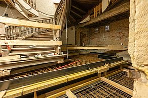 In eiAuf dem Boden vor einer Spindeltreppe liegen Baustahlmatten. Das Treppenhaus befindet sich in einem Rohbau.