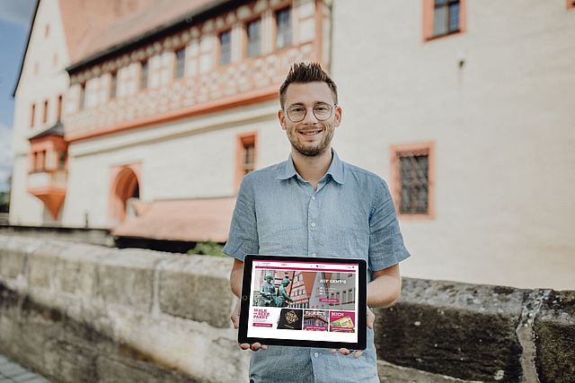 Nico Cieslar mit Tablet-Computer vor der Kaiserpfalz.