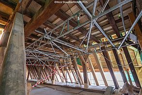 Ein Metallgestell mit vielen Verstrebungen verankert im Dachraum eine Materialplattform