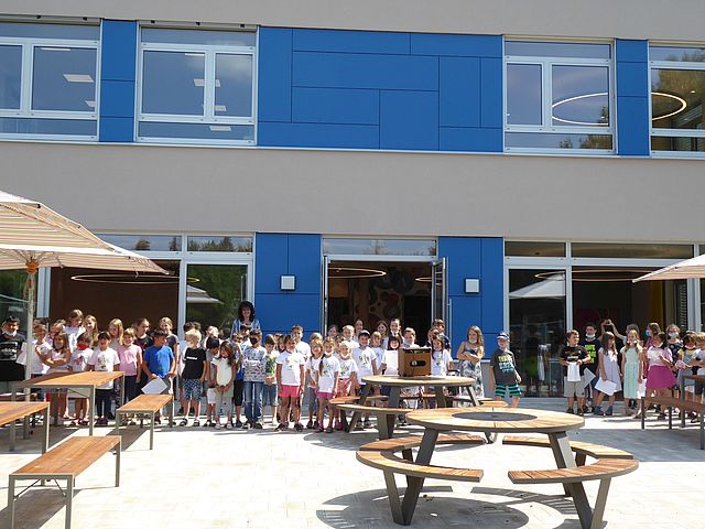 Kinder vor dem Gebäude der Mittagsbetreuung.