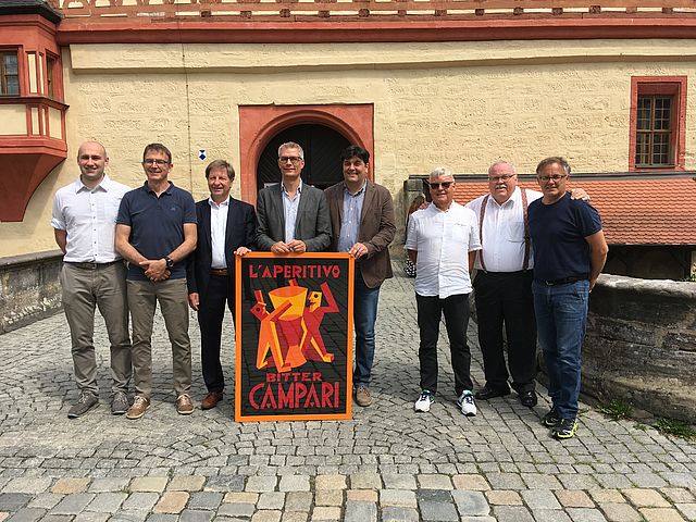 Die Übergabe des Gastgeschenks aus Rovereto, eine Reproduktion einer Plakatwerbung aus den 30-er Jahren vom weltbekannten Roveretaner Futuristen Fortunato Depero. Foto: Stadt Forchheim