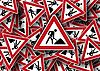 Mehrere Baustellen-Verkehrsschilder liegen wahllos übereinander